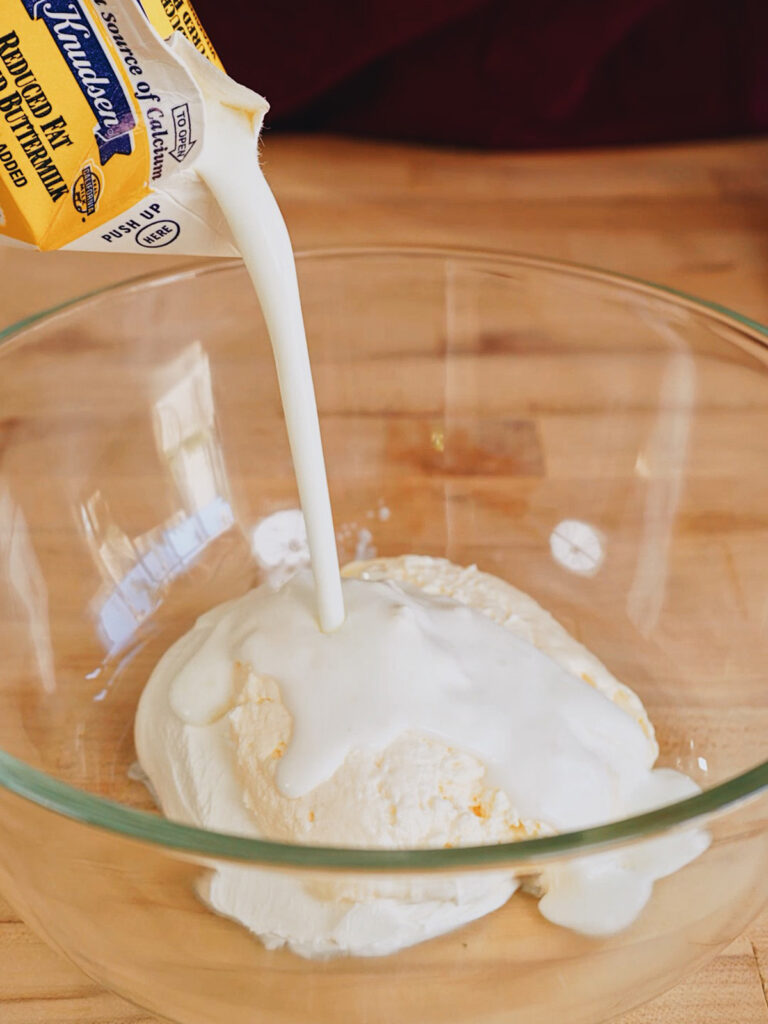 Pouring buttermilk into the base for the Copycat Wingstop Ranch Recipe