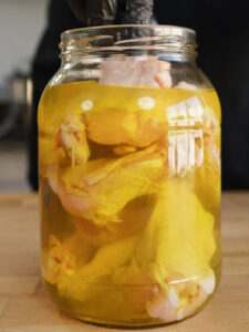 Pickle Brined Chicken Wings being place in a jar