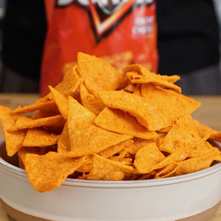 Stacked chips in a bowl featuring the best 15-minute homemade Doritos recipe, a food science copycat by Roice Bethel (@noflakeysalt) using Hoosier Hill Farm cheddar powder.