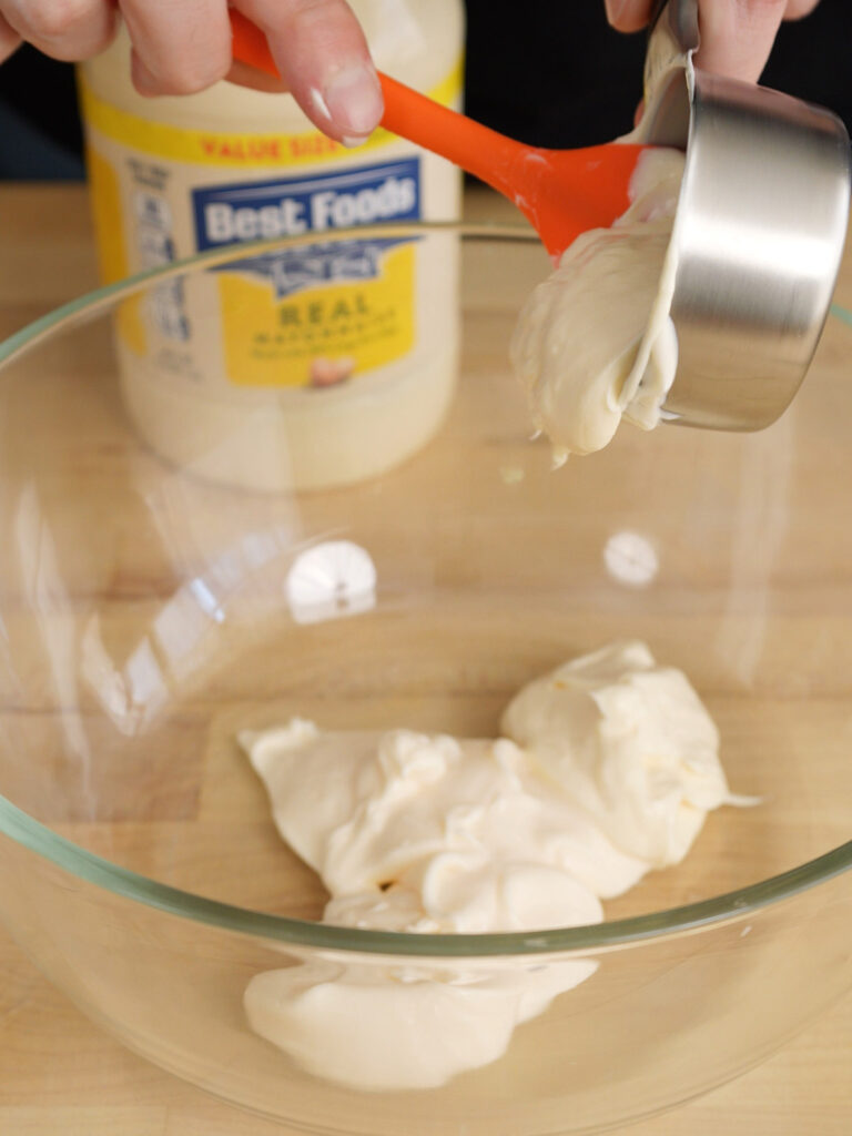 Scooping real mayonnaise into a glass mixing bowl to start the dipping sauce base.
