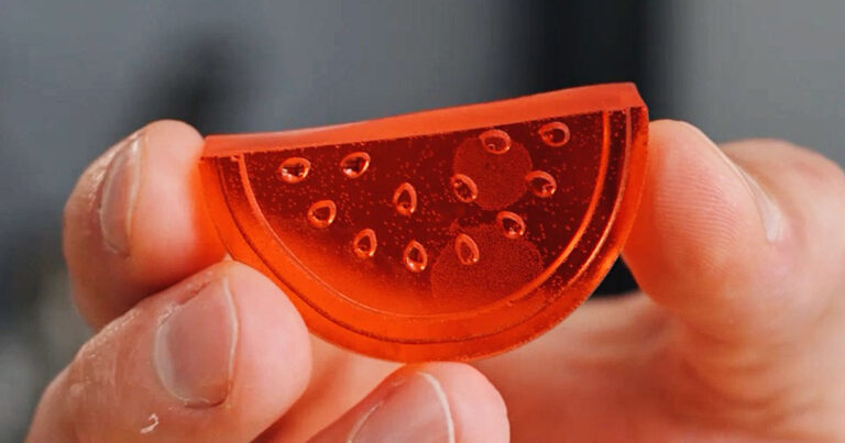 A clear, uncoated red gummy shaped like a watermelon slice, showcasing the perfect chewy texture of this Homemade Watermelon Sour Patch treat.